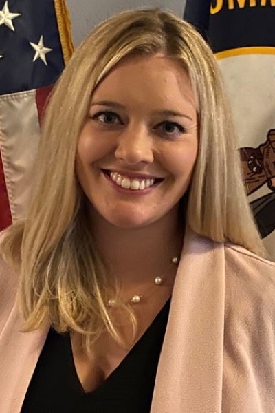 Portrait of Michon Lindstrom in front of the American and Kentucky flags.